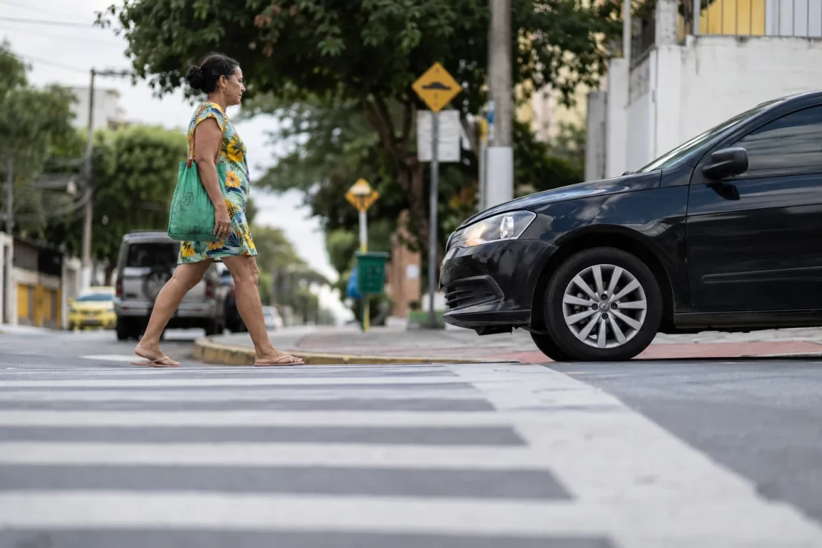 Pedestre atravessando na faixa com carro parado respeitando a preferência